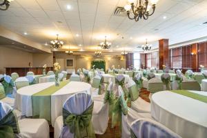 un salón de banquetes con mesas blancas y sillas con arcos verdes en Comfort Inn & Suites Surrey, en Surrey