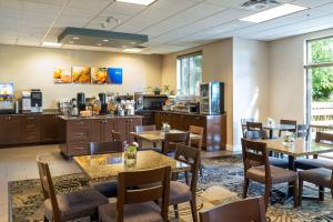 a restaurant with tables and chairs and a kitchen at Comfort Inn & Suites Surrey in Surrey