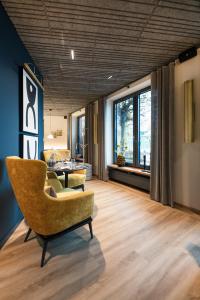 a living room with a chair and a table at Thöles Hotel Bücken in Bücken