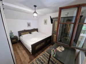 a bedroom with a bed and a table and a mirror at Pensiunea Bradet in Broşteni