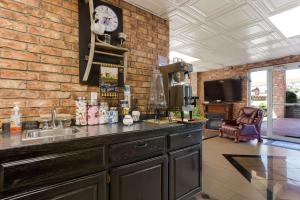 a kitchen with a sink and a brick wall at Rodeway Inn Branson, Brick House in Branson