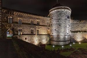a large brick building with a tower at night at NEU I moderne zentrale Wohnung I Netflix I 4 Gäste in Andernach