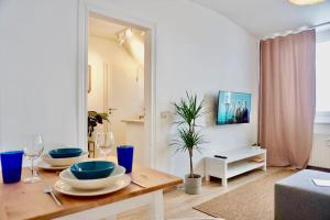 a living room with a table with plates and wine glasses at NEU I moderne zentrale Wohnung I Netflix I 4 Gäste in Andernach