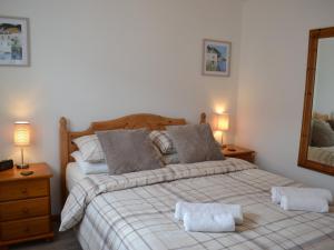 a bedroom with a large bed and a mirror at Summer Breeze in St Austell