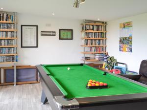 a living room with a pool table and books at Summer Breeze in St Austell