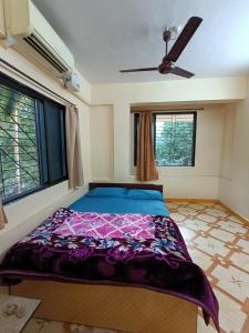 a bedroom with a bed in a room with windows at Sahil Residency in Murud