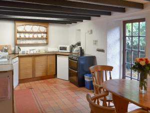 cocina con mesa de madera y mesa y comedor en Mill Cottage, en Buckfastleigh