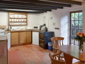 a kitchen with a wooden table and a table and a dining room at Mill Cottage in Buckfastleigh