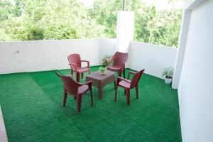 - un balcon avec une table et des chaises dans l'établissement EMFORE ELANZA, à Kottayam