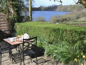 a table and chairs on a patio with a view of a lake at Nells Cottage in Askam in Furness