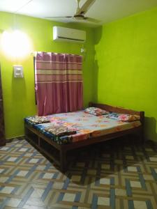 una camera con un letto in una stanza verde di UK homestay a Malwan