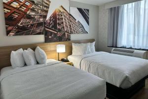 a hotel room with two beds and a window at Days Inn by Wyndham Brooklyn Eastern Parkway in Brooklyn