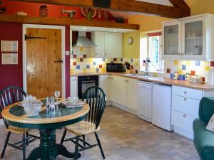a kitchen with a table and chairs in a kitchen at Barleycorn in Holwell