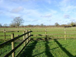 a wooden fence in the middle of a field at Barleycorn in Holwell