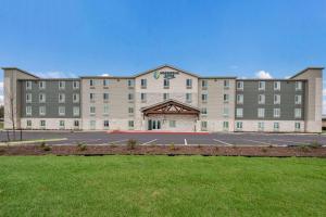 a large building with a parking lot in front of it at WoodSpring Suites San Antonio UTSA - Medical Center in San Antonio