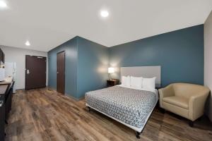 a hotel room with a bed and a chair at WoodSpring Suites San Antonio UTSA - Medical Center in San Antonio