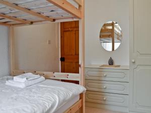 a bedroom with a bed and a dresser and a mirror at Daisy Bank Cottage in Bowness-on-Windermere