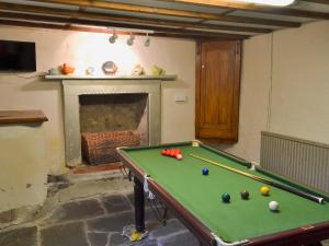 a room with a pool table and a fireplace at Daisy Bank Cottage in Bowness-on-Windermere
