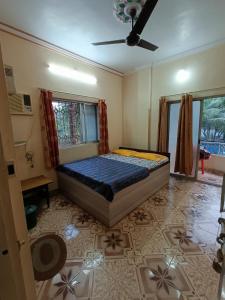 1 dormitorio con 1 cama y ventilador de techo en Sahil Residency, en Murud