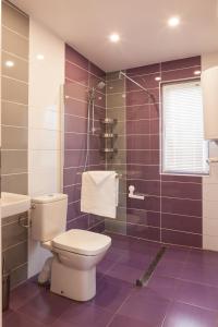 凱拉派特的住宿－Krapets Holiday Villas，紫色浴室设有卫生间和水槽