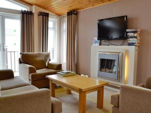 a living room with a tv above a fireplace at Kingfisher Lodge in Gorleston-on-Sea