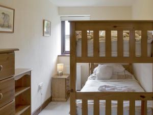 a bedroom with two bunk beds and a window at Homeleigh in Poundstock
