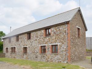 ein altes Steingebäude mit Fenstern in der Unterkunft Homeleigh in Poundstock