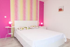 Krapets Holiday Villas في كرابيتس: غرفة نوم بسرير أبيض وجدران أرجوانية