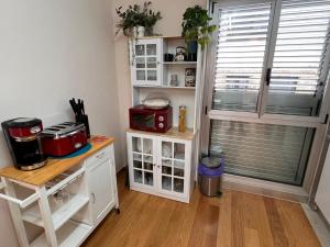 a kitchen with white cabinets and a window and a table at Loft con PARKING "Hygge Urbano Coruña" in A Coruña