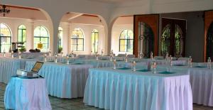 a room filled with tables with white tablecloths at Hotel Oaxtepec in Oaxtepec