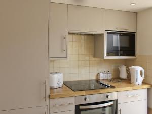 a kitchen with white cabinets and a counter top at Anchor Cottage in Deal