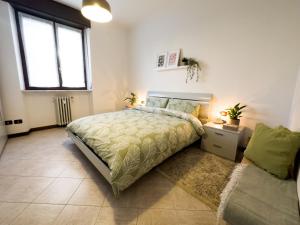 a bedroom with a bed and a window and a couch at Litta's flat in Affori - 3 mins walk from MM3 in Milan