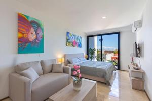 een woonkamer met een bank en een bed bij Luxury Studios On The 5th avenue Ocean View Rooftop I By Yeah in Playa del Carmen +89 foto's