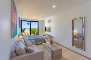 een woonkamer met een bank en een bed bij Luxury Studios On The 5th avenue Ocean View Rooftop I By Yeah in Playa del Carmen