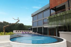 uma piscina em frente a um edifício em FOX HARRIS Hotel & Convention Banjarnegara em Banjarnegara
