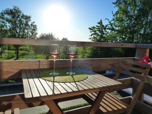 two glasses of wine sitting on a wooden table at Entre monts et collines B&B et espace détente in Mont-de-l'Enclus