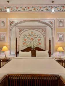 Pachār的住宿－Mundota Fort And Palace，卧室配有一张大床,墙上挂有绘画作品