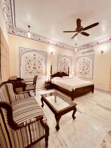 PachārにあるMundota Fort And Palaceのベッドルーム1室(ベッド1台、ソファ、テーブル付)