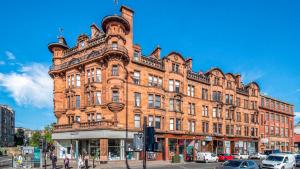 um grande edifício de tijolos na esquina de uma rua em 69 St Georges Mansions em Glasgow