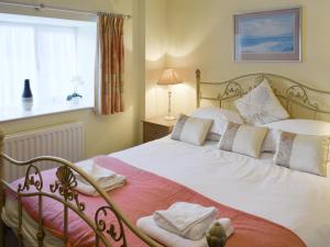 a bedroom with a bed with white sheets and a window at Beech Ghyll in Grasmere