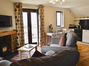 a living room with a couch and a fireplace at The Bothy in Bradworthy