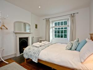 a white bedroom with a large bed and a window at Lower Margate Bodmin in Bodmin