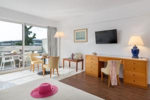 un soggiorno con una camera con tavolo e TV di Dionysos Hotel a Ixiá