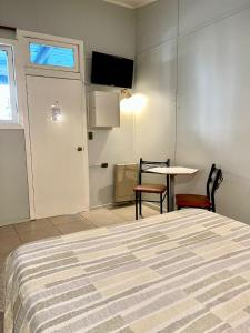 1 dormitorio con cama, mesa y puerta en Motel ZAVA, en Los Andes