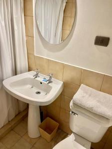 y baño con lavabo, aseo y espejo. en Motel ZAVA, en Los Andes
