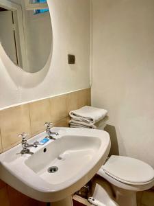 a bathroom with a sink and a toilet and a mirror at Motel ZAVA in Los Andes