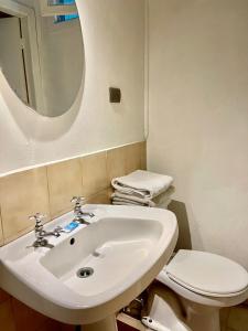 y baño con lavabo, aseo y espejo. en Motel ZAVA, en Los Andes