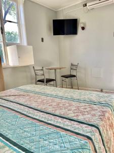 1 dormitorio con 1 cama, mesa y sillas en Motel ZAVA, en Los Andes