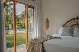 a bedroom with a bed and a sliding glass door at Panta Rei resort in Ahangama