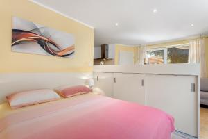 um quarto com uma cama grande e lençóis cor-de-rosa em Apartments Ljubica Pulj em Fažana